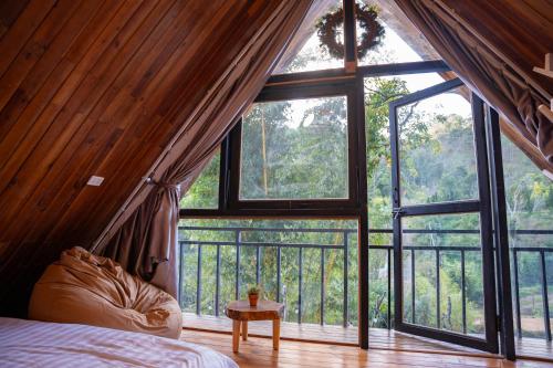 a bedroom with a large window in a tree house at tinys house in Lạc Dương