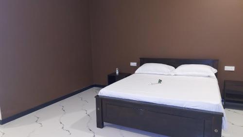 a bedroom with a bed with white sheets and pillows at Orion Blue Hotel in Dombagahawatta