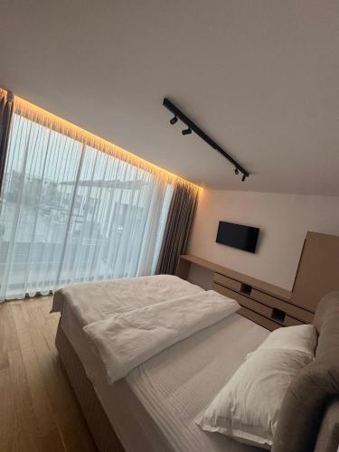 a bedroom with a large bed and a large window at Knight Rooms in Voluntari