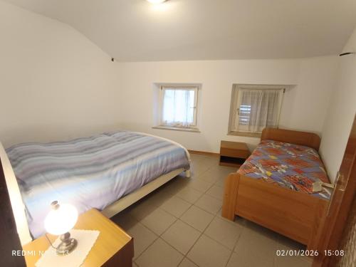 a bedroom with a bed and a table and a chair at La casa del Gianni in Piano