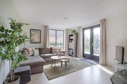 a living room with a couch and a tv at 6 - Person 'de Vlaamse Reus' 195 Bungalow in Ewijk