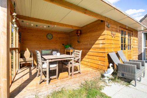 a patio with a table and chairs on a deck at 6 - Person 'de Vlaamse Reus' 195 Bungalow in Ewijk