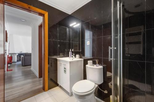 a bathroom with a toilet and a sink and a shower at AGUALVA HAPPY APARTMENT in Paiõis