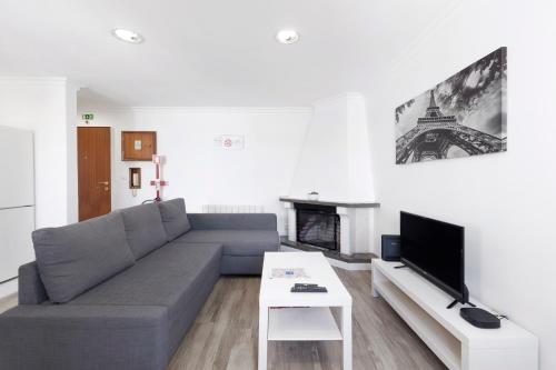 a living room with a couch and a tv at AGUALVA HAPPY APARTMENT in Paiõis
