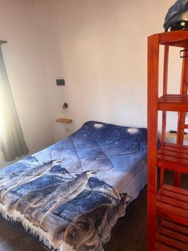 a bed in a room with a blue blanket at Rojavitiva in General Belgrano