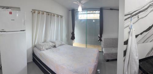 een kleine slaapkamer met een bed en een raam bij Kitnet em Cabo Frio 02 in Cabo Frio