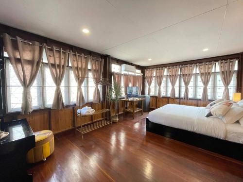 een slaapkamer met een groot bed en ramen bij The Memory Hostel Trat in Trat