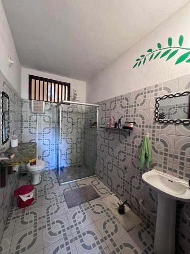 a bathroom with a shower and a toilet and a sink at Casa na Floresta in Itacaré