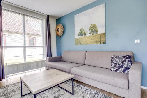 a living room with a couch and a table at 4 - Person Lakeside 47 Bungalow in Ewijk