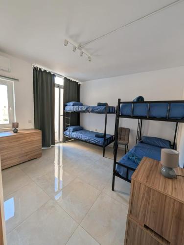 a room with three bunk beds and a table at Lourd Bed in Sliema