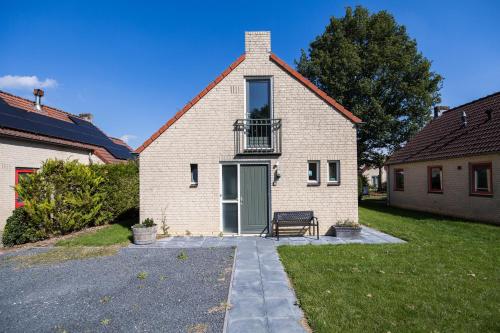 a white brick house with a bench in front of it at 6 - Persons Lake Area 40 Bungalow in Ewijk
