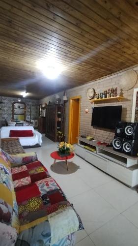 a large room with two beds and a flat screen tv at Pousada e Residencial Linda in Capão da Canoa