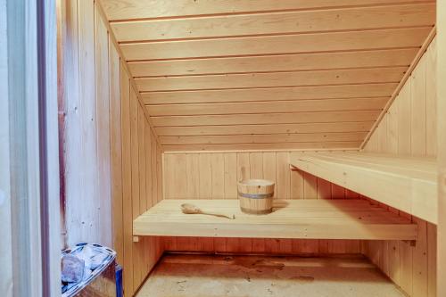 a wooden sauna with a cup and a bucket at 5 - Person Forest 239 Sauna Bungalow in Ewijk