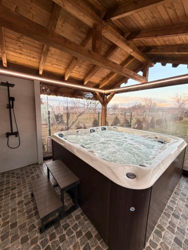 a jacuzzi tub in a building with a wooden ceiling at Greenview Villa Sofia in Drenovo