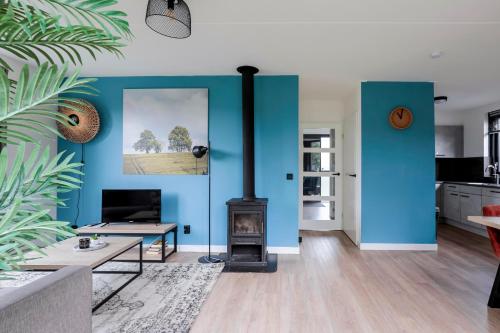 a living room with blue walls and a wood stove at 6 - Persons Lakeside 7 Bungalow in Ewijk
