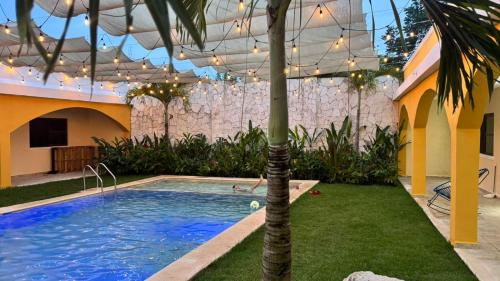 a swimming pool in a yard with a palm tree at Hotel Villa Chucum-Tikuch in Tikuch