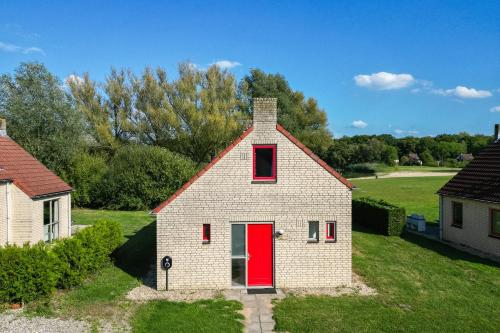 a small white house with a red door at 6 - Persons Lakeside 25 Bungalow in Ewijk