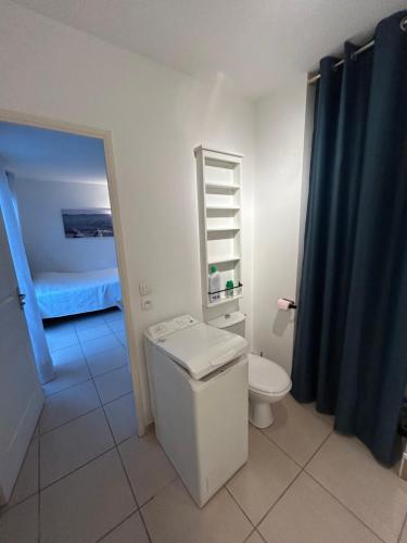 a bathroom with a toilet and a bathroom with a bed at Studio a 3 mn à pied des thermes in Balaruc-les-Bains