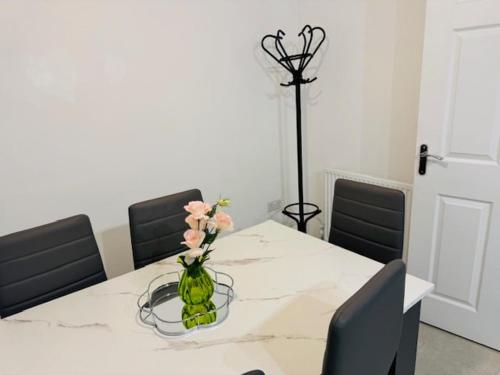 a dining room table with a vase with flowers in it at Cherry Barn Haven in Wisbech Saint Mary