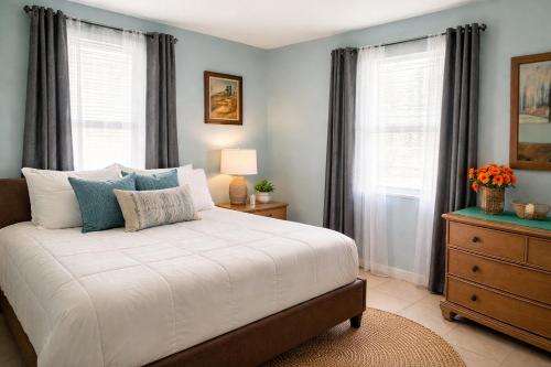 a bedroom with a bed and a dresser with windows at One-Bedroom Suite Pool with Bath Kitchen in West Palm Beach in West Palm Beach