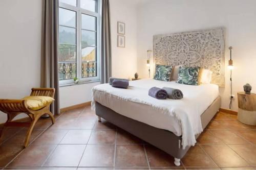 a bedroom with a large bed and a large window at House Bali Furnas in Furnas