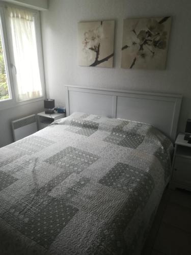 a bedroom with a bed with a quilt on it at Residencia Odyssee in Vieux-Boucau-les-Bains
