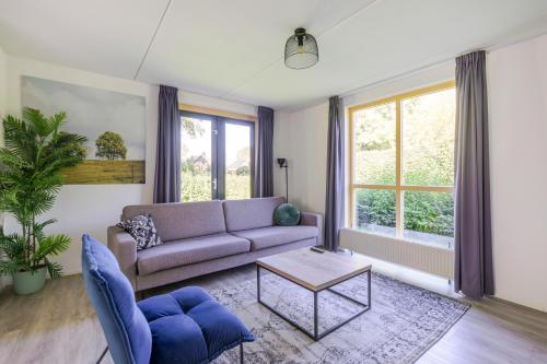 a living room with a couch and a table at 4-Person Forest 159 Bungalow in Ewijk
