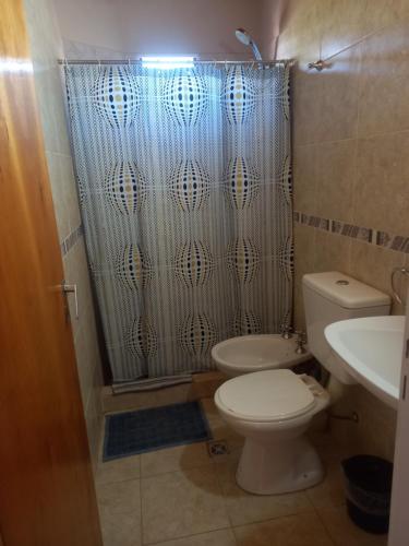 a bathroom with a toilet and a shower curtain at Departamentos RIMASHA in Federación