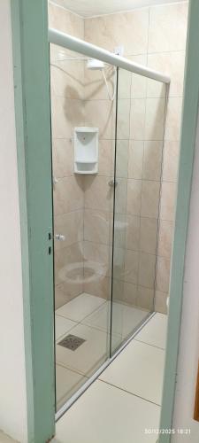 a shower with a glass door in a bathroom at Vida Mansa Apartamentos in Capão Novo