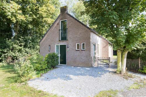 an old brick house with a window and a door at 5-Person Forest 271 Bungalow in Ewijk