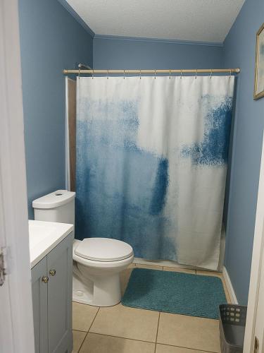 a bathroom with a toilet and a shower curtain at Spacious Studio with Pool access & bathroom kitchen in West Palm Beach in West Palm Beach