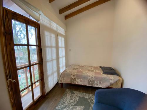 a bedroom with a bed and a window at La Casona - Hospedaje Campestre in El Carmen