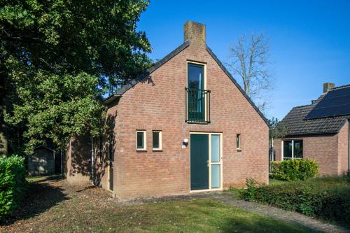 a brick house with a green door and a window at 6 - Persoons Forest 185 Bungalow in Ewijk