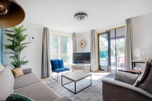 a living room with a couch and a tv at 6 - Persoons Forest 193 Bungalow in Ewijk