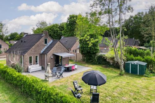 a house with an umbrella in the yard at 6 - Persoons Forest 193 Bungalow in Ewijk