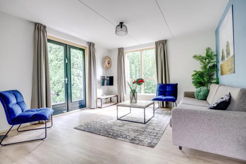 a living room with a couch and blue chairs at 6 - Persoons Forest 231 Bungalow in Ewijk