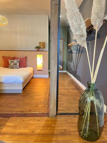 a room with a bed and a vase with flowers in it at La Galupe in Mont-de-Marsan