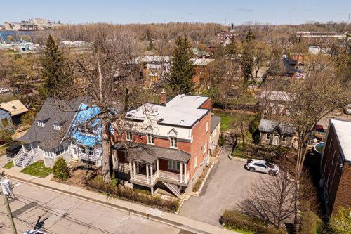 a large house with a car parked in front of it at Appartements Saint-Alexandre in Longueuil
