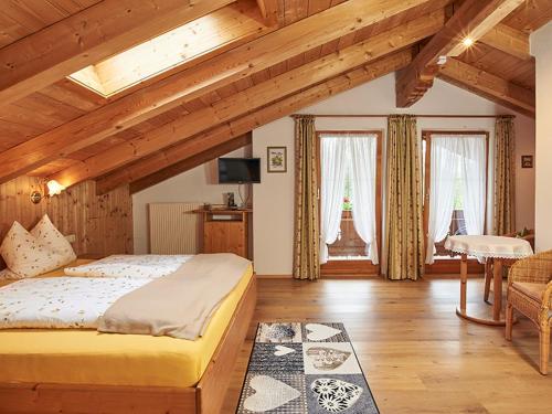 a bedroom with a large bed in a room with wooden ceilings at Landhaus Eschenbach in Schönau am Königssee