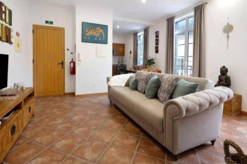 a living room with a couch and a television at House Bali Furnas in Furnas