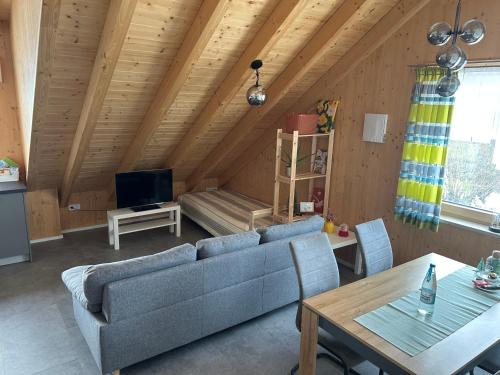 een woonkamer met een bank en een tafel bij Holzliebe mit Donaublick in Kaisheim