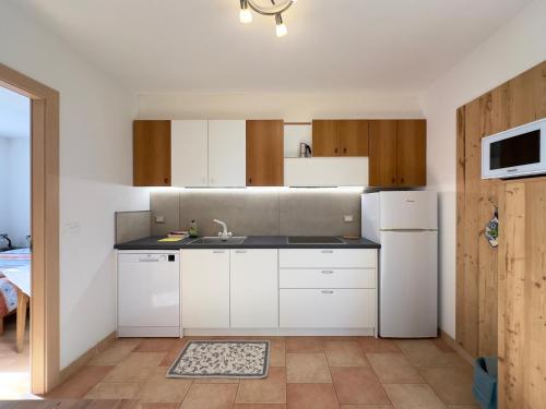 una cucina con mobili bianchi e un lavandino di Appartamenti LITEGOSA casa vacanza 2 a Panchia