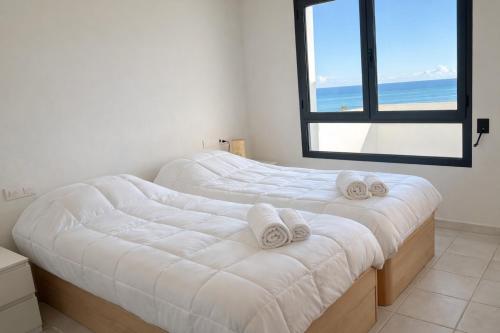 twee bedden in een kamer met uitzicht op de oceaan bij Apartamento Califato 5 in Mojácar