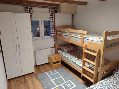 a bedroom with two bunk beds and a door at Petra Kuća Apartmani Studio Divčibare Петра Кућа Апартмани Студио Дивчибаре in Divčibare