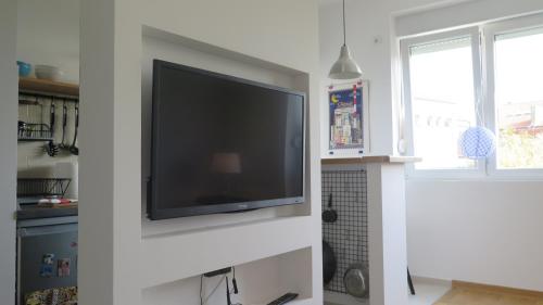 a flat screen tv on a wall in a kitchen at Vracar Superb Apartment in Belgrade