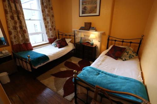 two twin beds in a room with a window at Corratavey Guest Accommodation in Ballycastle
