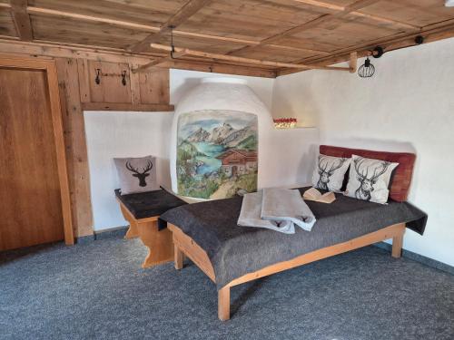 ein Schlafzimmer mit einem Bett und einem Gemälde an der Wand in der Unterkunft Ferienhaus Carmen in Grän