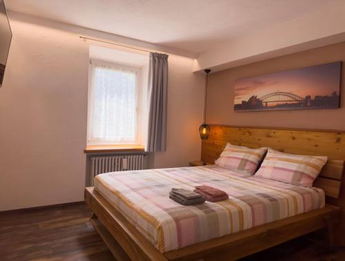 a bedroom with a bed with a striped blanket and a window at Appartamenti LITEGOSA casa vacanza 1 in Panchià