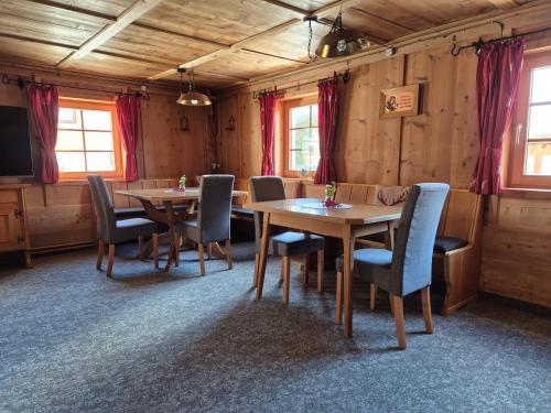 ein Esszimmer mit Tischen und Stühlen und einem Fernseher in der Unterkunft Ferienhaus Carmen in Grän