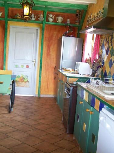 Maison d'artiste في Sainte-Colombe-en-Bruilhois: مطبخ بجدران خضراء برتقالية
